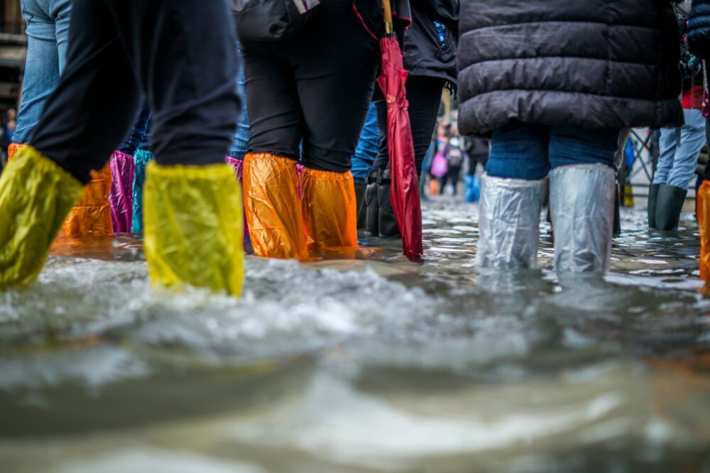 personne avec les pieds dans l'eau après une inondation